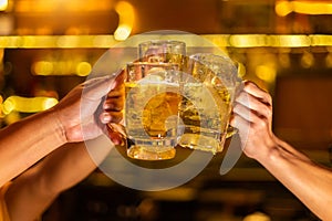 Cheers, Group of happy friends drinking and toasting beer at brewery bar restaurant, mugs of beer