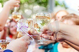 Cheers. Group of people drinking and toasting in restaurant. Hands holding glasses of champagne and wine making toast