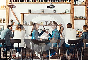 Cheers to the weekend. a young couple enjoying a drink at a bar.