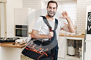 Cheery positive man plumber pointing to himself