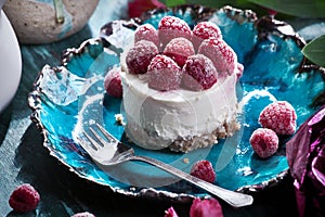 Cheescake with raspberry closeup on a beautiful handmade ceramic plate