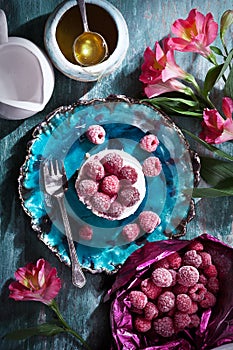 Cheescake with raspberry closeup on a beautiful handmade ceramic plate