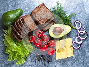 Cheese, avocado, tomato, green sprouts, black bread, salad, onion. Grey background