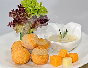 Cheese balls with dip served in a dish isolated on table side view