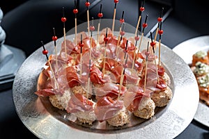 Cheese balls sprinkled with grated almonds, covered with jamon.