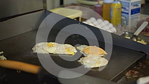 Cheese being placed on eggs at a deli