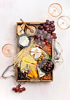 Cheese board with grapes, nuts and dried fruits, overhead view photo