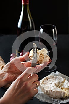 Cheese board with hard mature cheese, antique knife and corkscrew. Selective focus