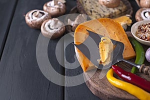Cheese on the board and spices. Black background
