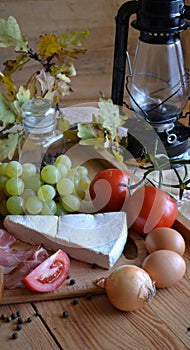 Cheese, bread, onions, wine, tomatoes and a kerosene lamp