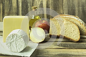 Cheese with bread and onions on a wooden table