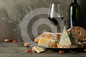 Cheese, bread, red wine, and walnuts on a kitchen table