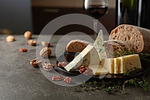 Cheese, bread, red wine, and walnuts on a kitchen table