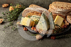 Cheese, bread, walnuts, and thyme on a stone kitchen table