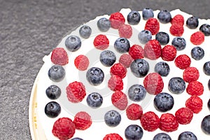 Cheese cake strawberry and raspberry on creamy white flat layer. Cooking at home. Recipe and cooking activity with pastry and