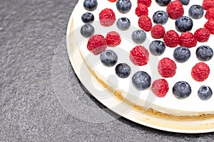 Cheese cake strawberry and raspberry on creamy white flat layer. Cooking at home. Recipe and cooking activity with pastry and