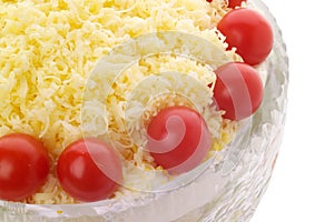 Cheese and cherry tomato topped salad in crystal bowl