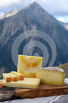 Cheese collection, French beaufort, abondance, emmental, tomme de savoie cheeses served outdoor in Savoy region, with Alpine
