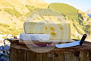 Cheese collection, French emmental, tomme and reblochon de savoie cheeses served outdoor in Savoy region, with Alpine mountains