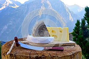 Cheese collection, French emmental, tomme and reblochon de savoie cheeses served outdoor in Savoy region, with Alpine mountains