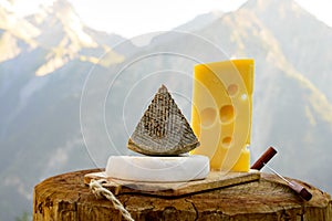 Cheese collection, French emmental, tomme and reblochon de savoie cheeses served outdoor in Savoy region, with Alpine mountains