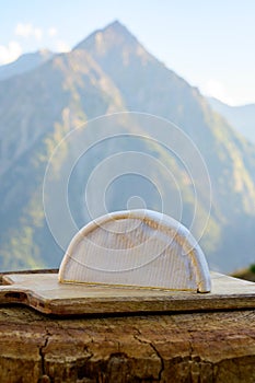 Cheese collection, French reblochon de savoie cheese served outdoor in Savoy region, with Alpine mountains peaks on background