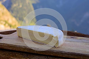 Cheese collection, French reblochon de savoie cheese served outdoor in Savoy region, with Alpine mountains peaks on background