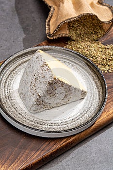 Cheese collection, French tomme cailladou cheese made with aromatic herbs of provence rosematy, thyme,  origano