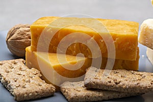 Cheese collection, matured and orange original British cheddar cheese in blocks served on grey plate