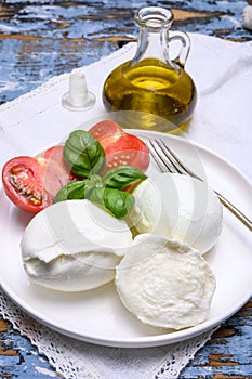 Cheese collection, organic mozzarella soft cheese served with ripe tomato and fresh green basil