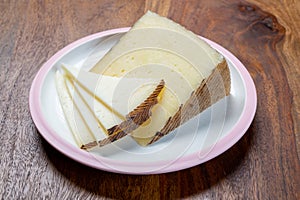 Cheese collection, pieces of different sheep hard manchego cheeses made in La Mancha, Spain served on white board