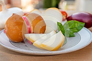 Cheese collection, variety of Italian cow milk cheese scamorza with Italian houses on background