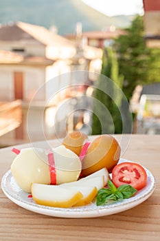Cheese collection, variety of Italian cow milk cheese scamorza with Italian houses on background