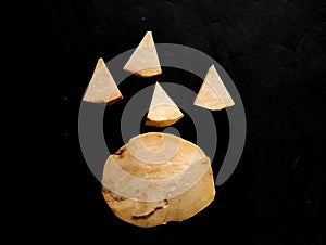 a cheese cut into a triangle on a black background
