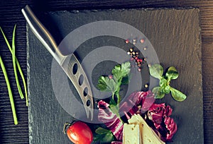 Cheese delikatessen closeup on black stone desk surface