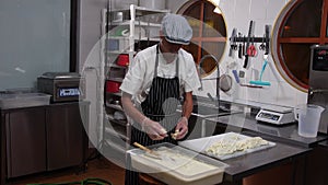 Cheese factory - man worker putting pieces of soft cheese in container with liquid