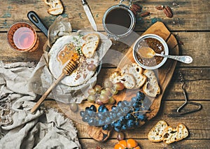 Cheese, fruit, nut and wine set over rustic wooden background