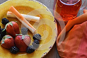 Cheese,fruit, on a vibrant plate with a glass of juice