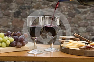 Cheese, grapes, bread, wine on a table
