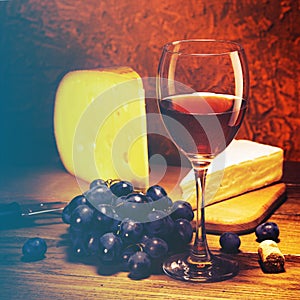 Cheese, grapes and glass of red wine.