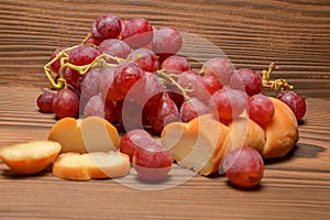 Cheese and grapes on wooden background with copy space, selective focus