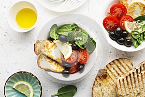 Cheese haloumi brown rice bowl with tomatoes, olives, lemon and pine nuts. Top View photo