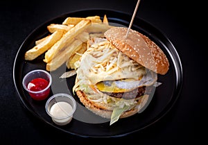 Cheese hamburgers sandwich with fried potatoes with black background, nice