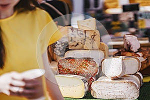 Cheese heads on market counter. Selective focus. Gastronomic dairy produce, real scene, farm food