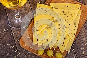 Cheese with hemp seeds near glass of wine