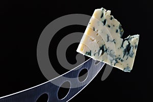 Cheese and knife on black background