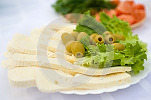 Cheese, lettuce and olives on plate