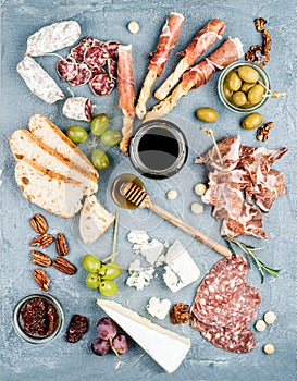 Cheese and meat appetizer selection or wine snack set. Variety of cheese, salami, prosciutto, bread sticks, baguette