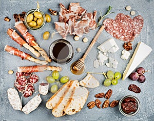 Cheese and meat appetizer selection or wine snack set. Variety of cheese, salami, prosciutto, bread sticks, baguette