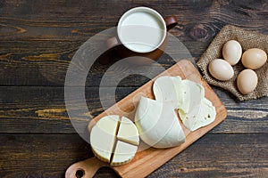 Cheese with milk on a wooden table. Top view